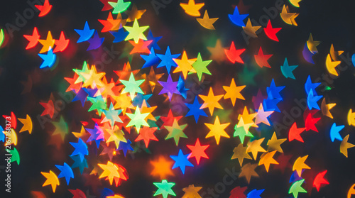 Abstract colorful star-shaped bokeh lights on a dark background