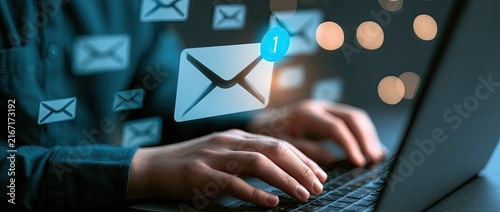 Person typing on a laptop with email icons floating around, representing digital communication and online messaging.