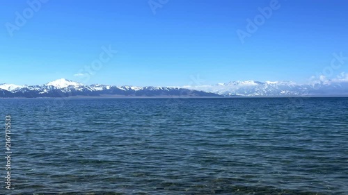 Beautiful scenic view of Sayram Lake with turquoise water and snow-capped Tianshan mountains in Xinjiang, China.