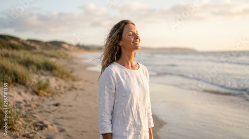 Serene Mature Woman Finding Inner Peace and Tranquility While Breathing Fresh Ocean Air on a Beautiful Sandy Beach During Golden Hour Sunset