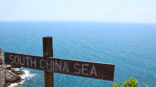 Obraz na płótnie Wooden South China Sea sign overlooks a sparkling tropical coastline