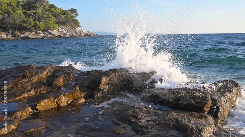 Powerful sea waves crashing against rocky coast of an island. Scenic view of ocean waves hitting rocks on a wild shore. Dramatic sea waves splashing on rocky cliffs