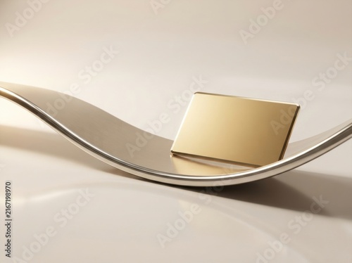 Blank gold credit card on a curved metallic platform for premium financial services concept.