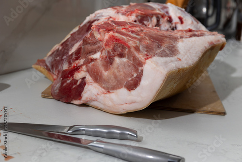 Fotografía Raw bone-in pork leg deboning in a home kitchen: authentic butcher realism
