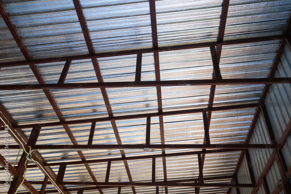 Obraz premium Corrugated metal roof steel frame industrial building interior geometric structure transparent daylight