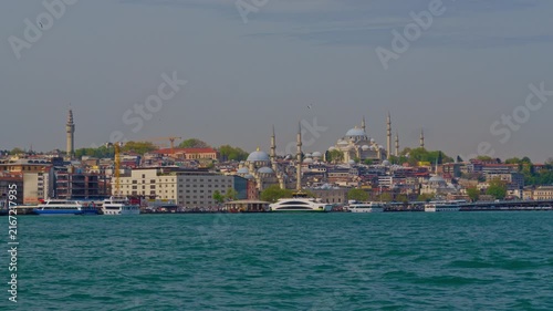 Wide panoramic view of the Istanbul cityscape featuring majestic Ottoman mosques and minarets along the waterfront under a clear sky during daytime