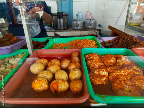 Foto Assorted traditional Indonesian dishes with spicy hard-boiled eggs and fried egg