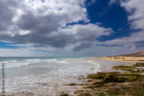Panoramic view of a sandy beach and turquoise ocean under a blue sky in Costa Calma – Canary Islands, Fuerteventura; background or wallpaper for your project