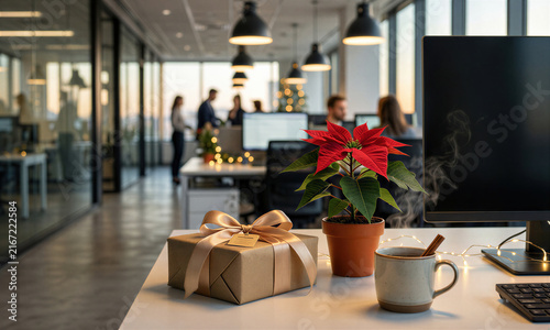 Elegant wrapped gift and poinsettia sharply focused on executive desk while unmistakable modern office environment with blurred figures creates festive professional atmosphere