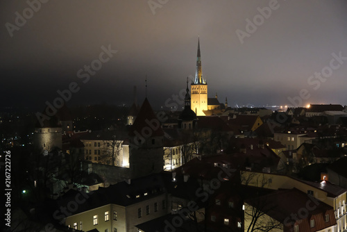 Outdoor high-angle view of Tallinn Old Town skyline at night with illuminated St. Olaf's Church in Estonia