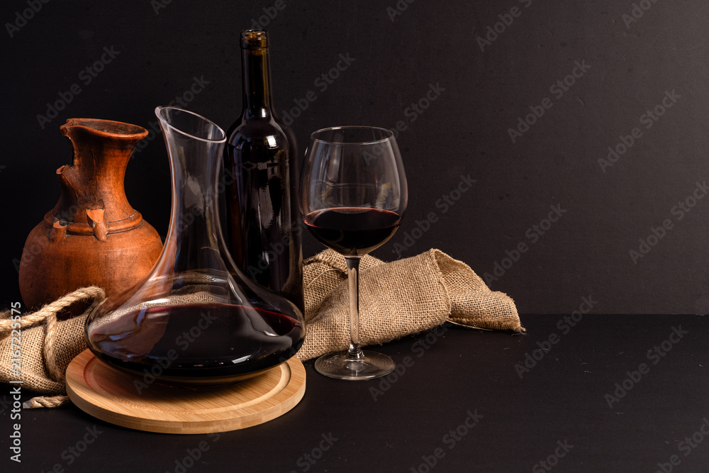 Naklejka premium Red wine decanter and glass with dark copy space