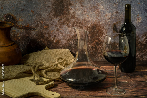 Bild auf Leinwand Rustic red wine still life with decanter and textured backdrop