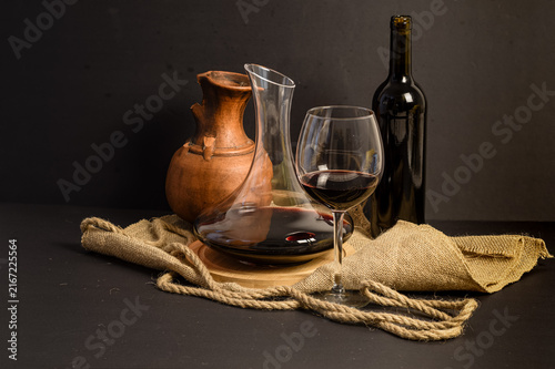 Foto Horizontal red wine still life with rustic clay jug