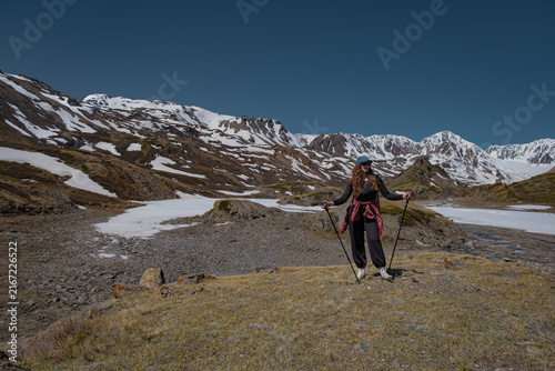 Cuadro en lienzo Full length of a young female hiker with trekking poles standing on a hill overl