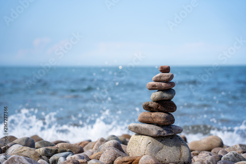 Photography Stacked Pebble Cairn By The Calm Blue Ocean