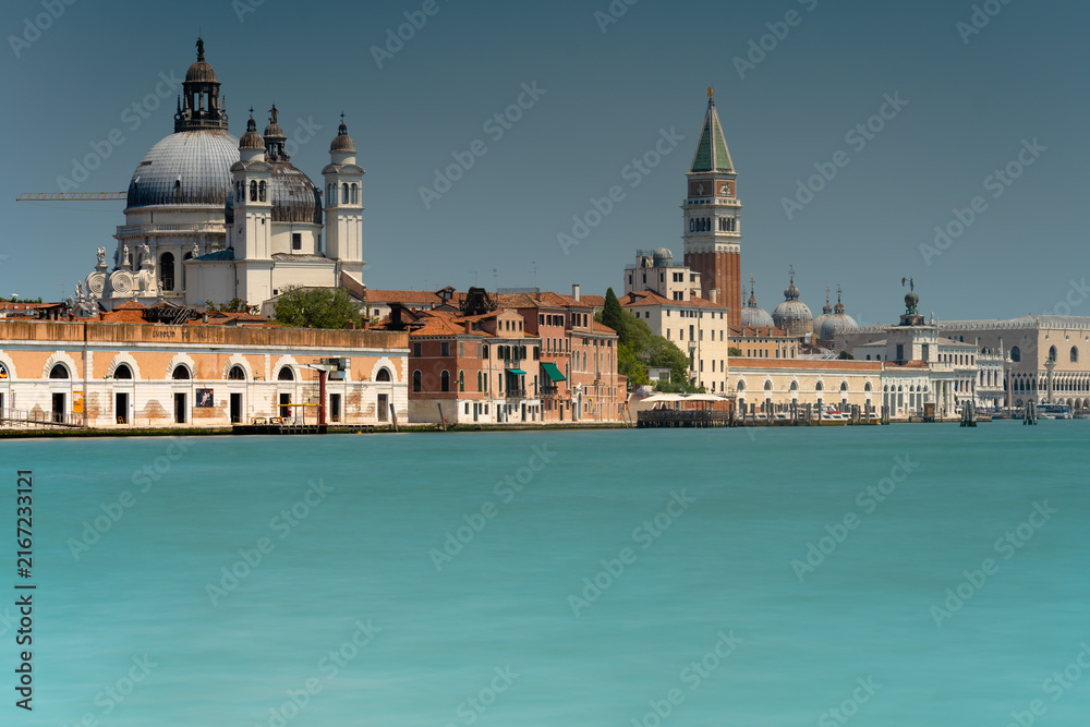 Fototapeta premium Venice Grand Canal Waterfront View with Santa Maria della Salute Basilica and St Marks Campanile Tower Under Clear Blue Sky