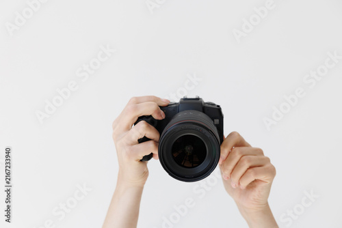 Foto Woman hands holding professional photo camera isolated