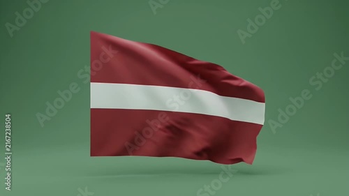 Latvian national flag waving in wind against solid green background for patriotic themes