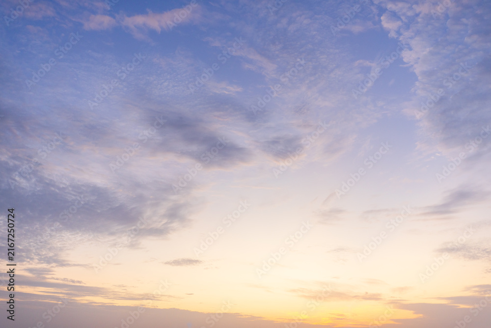 Fototapeta premium Serene Pastel Sunset Sky,A tranquil and serene sunset sky featuring soft, delicate clouds transitioning from a warm golden-orange glow at the horizon to a calm pastel purple and blue above, suitable.