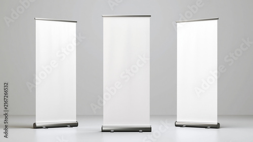 Professional commercial product photography of three identical blank white retractable roll up banner displays arranged side by side in a minimalist light gray studio