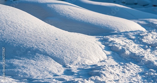 Deep snow mounds covering parked cars after heavy snowfall