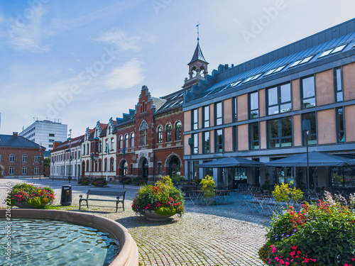 KRISTIANSAND, NORWAY - AUGUST 9, 2026: Historic former fire station Christiansands Brandvagt surrounded by urban architecture, outdoor seating, flowers and a fountain in central Kristiansand.