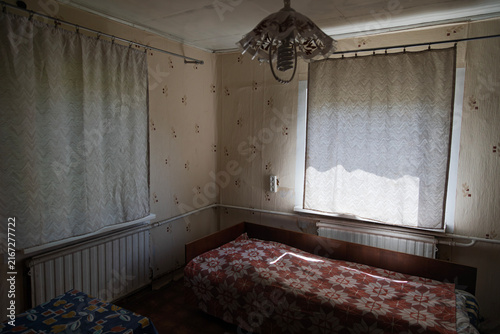 Cuadro en lienzo An interior view of a room with two beds, radiators, and curtains