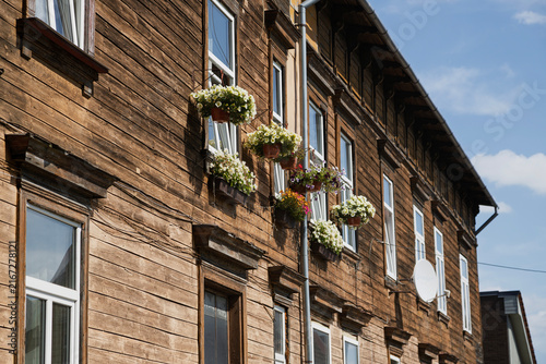 A wooden building with flower boxes hanging from the windows. Latvia Liepaja
