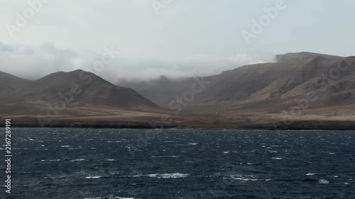 Canary Islands. Island scenery captured from a boat, highlighting the rocky formation and ocean waves with shifting angles in three sequential frames