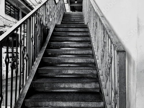 Dramatic black and white photograph exterior staircase of emotion concept loneliness. step, stair, aged, art, worn, up, moody, lines, symmetry, old, city, wall, vintage, white, outside