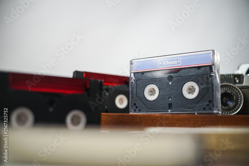 Vintage cassette tapes and film camera on wooden shelf