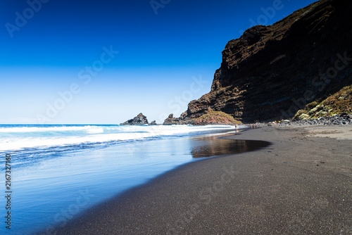 Waves washing ashore on black sand volcanic beach, La Palma.