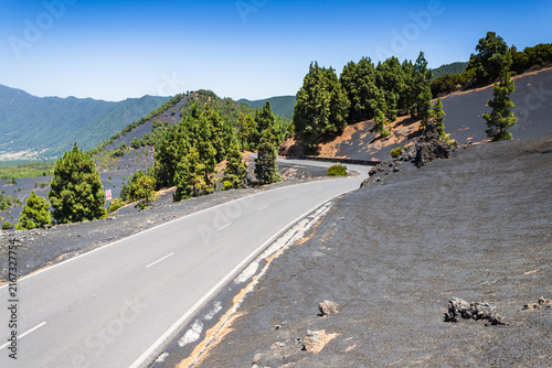 Asphalt mountain road passing through black volcanic ash fields in La Palma