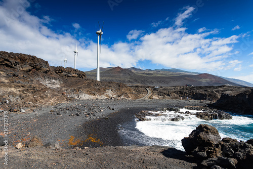Wind turbines on black volcanic coast near ocean in La Palma