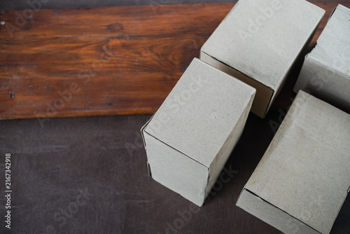 Plain cardboard boxes stacked on wooden board