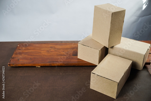 Plain cardboard boxes stacked on wooden board