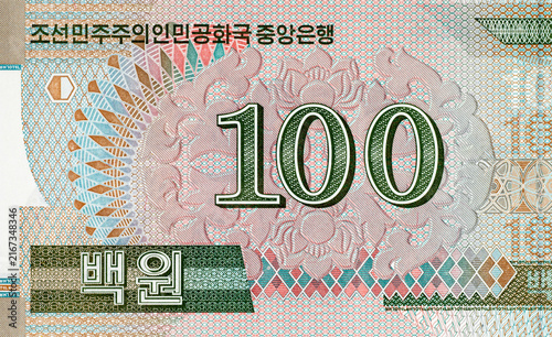 Photography North Korean 100 won banknote featuring ornate traditional geometric patterns and denomination numerals