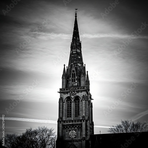 Tapety artystyczne Gothic Church Spire Rising Against Dramatic Cloudy Sky in Black and White