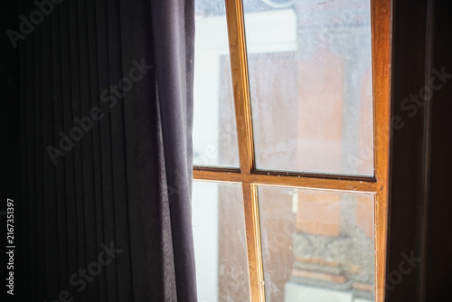 Old wooden window with dark curtains