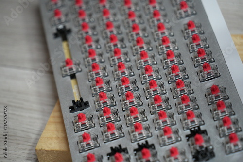 A mechanical keyboard plate with red switches installed.
