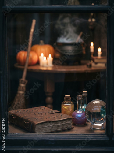 witchcraft still life with grimoire, potion bottles, and pumpkins in warm autumn tones for halloween decoration