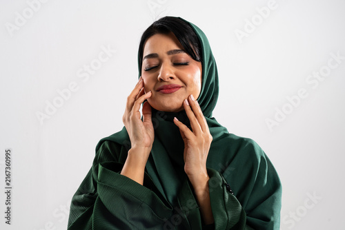 Принти на полотні Beautiful muslim woman wearing green hijab touching her face