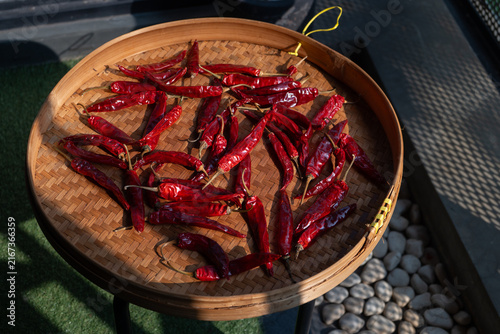 Dried chili peppers on traditional indonesian woven bamboo basket (besek), prepared to make sambal (spicy sauce), chili oil, or other hot dishes