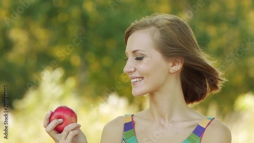 Young beautiful woman eating ripe red apple