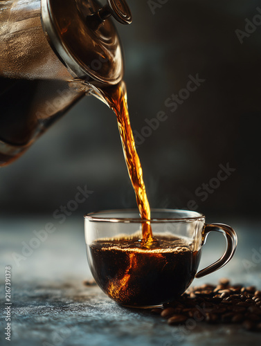 Pouring fresh brewed coffee into glass cup