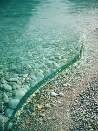 Clear ocean water washing over pebbles shoreline