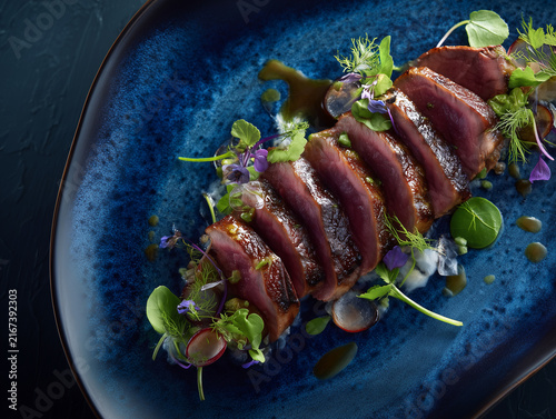 Plated gourmet duck breast with microgreens and radish