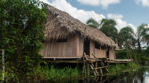 Canvas Print Serene Blackwater River and Traditional Stilt House in the Tropical Wetlands of