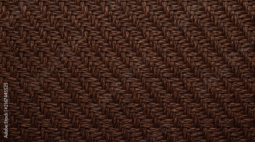 Horizontal close-up photo of a dark brown woven rattan or fabric texture background, tight geometric wicker pattern
