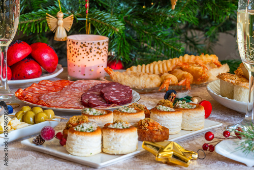 Christmas party, a selection of gourmet snacks and champagne set on a table. Selective focus
